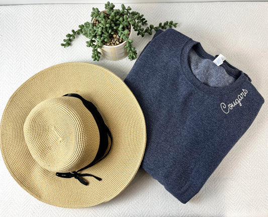 a hat, t - shirt and a plant on a white surface