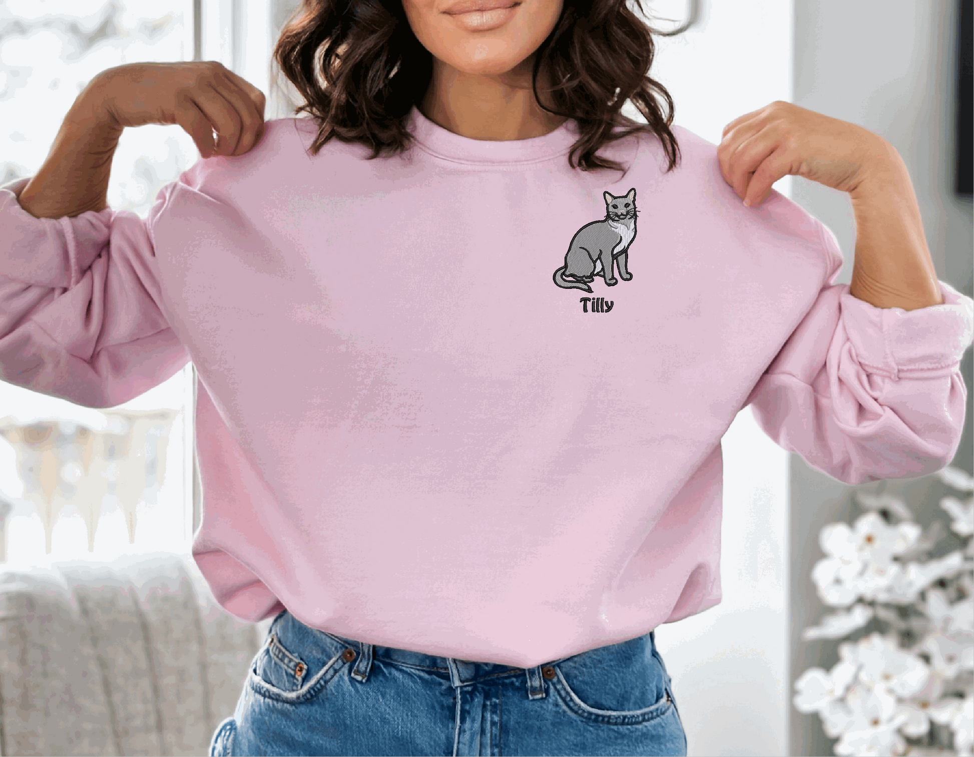a woman wearing a pink sweatshirt with a cat on it