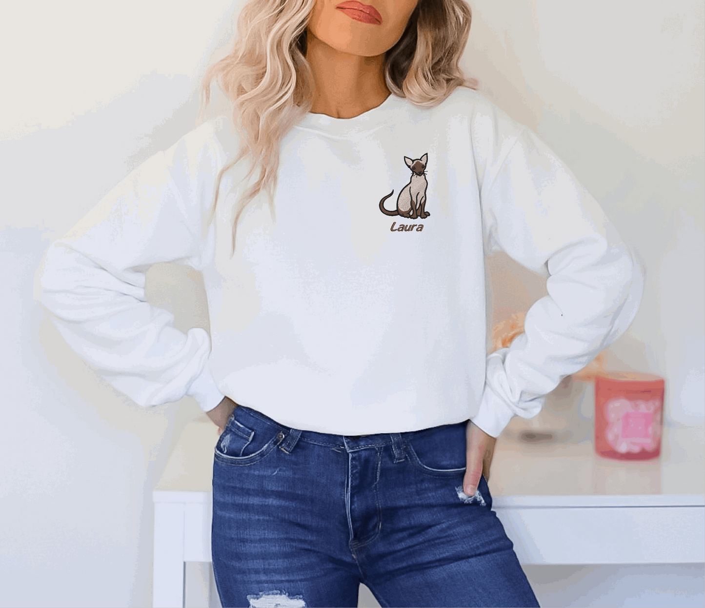 a woman wearing a white sweatshirt with a cat on it