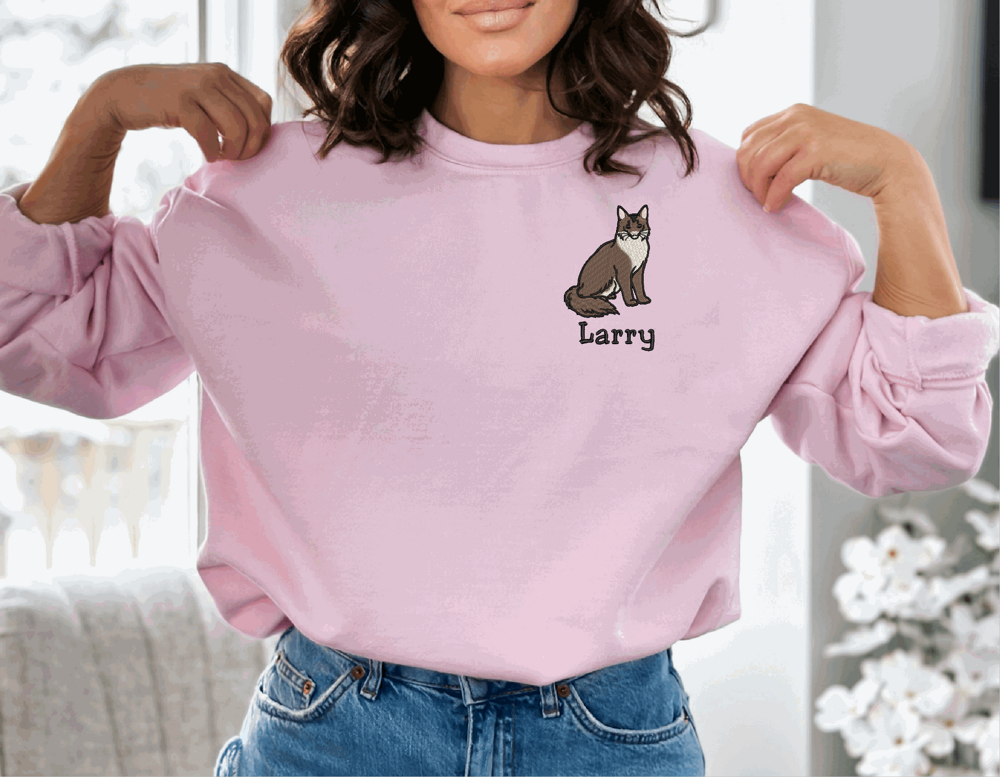 a woman wearing a pink sweater with a cat on it