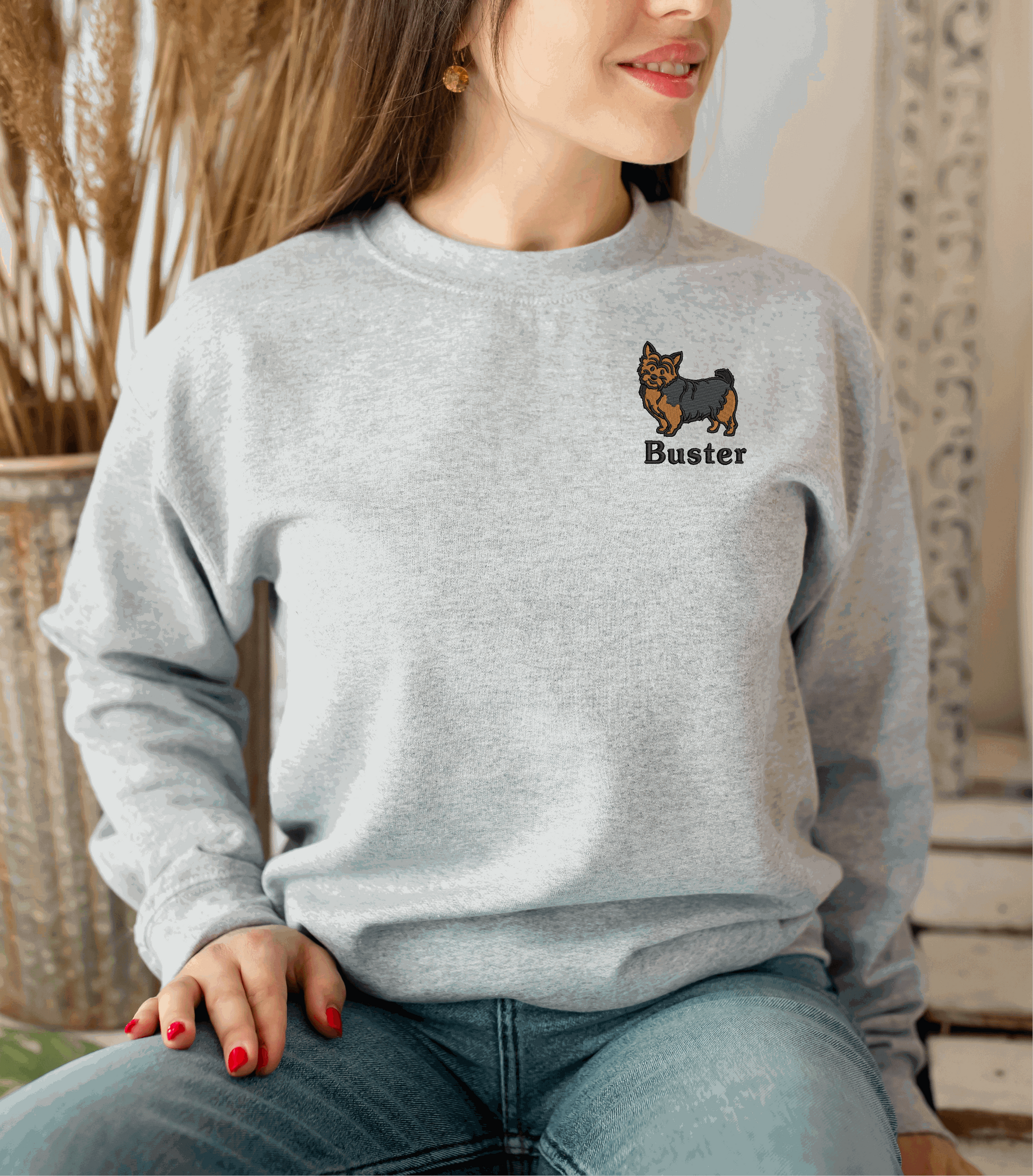 a woman sitting on a chair wearing a sweater with a dog on it