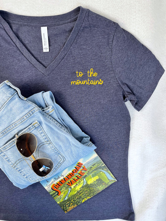 a pair of sunglasses and a book are laying on a pair of jeans